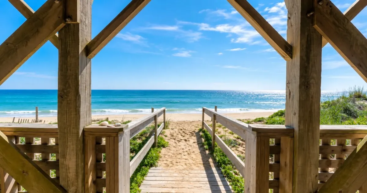 A wooden beach walkway opening onto the ocean